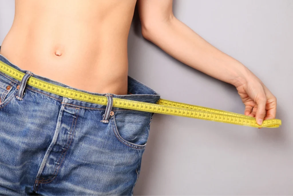 persona che indossa un paio di jeans ormai troppo larghi dopo aver fatto una dieta per perdere peso