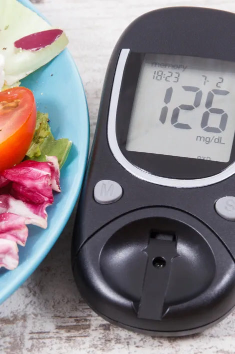 glucometro a fianco ad un piatto di insalata