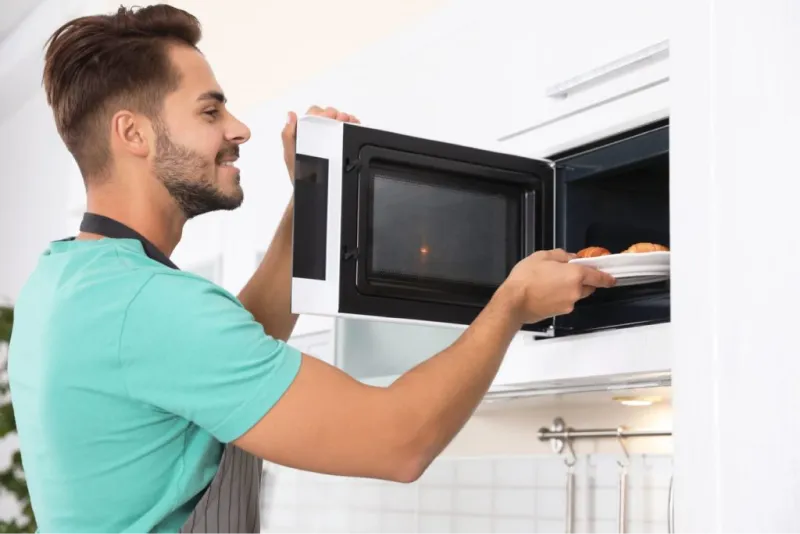 Ragazzo inserisce piatto nel microonde