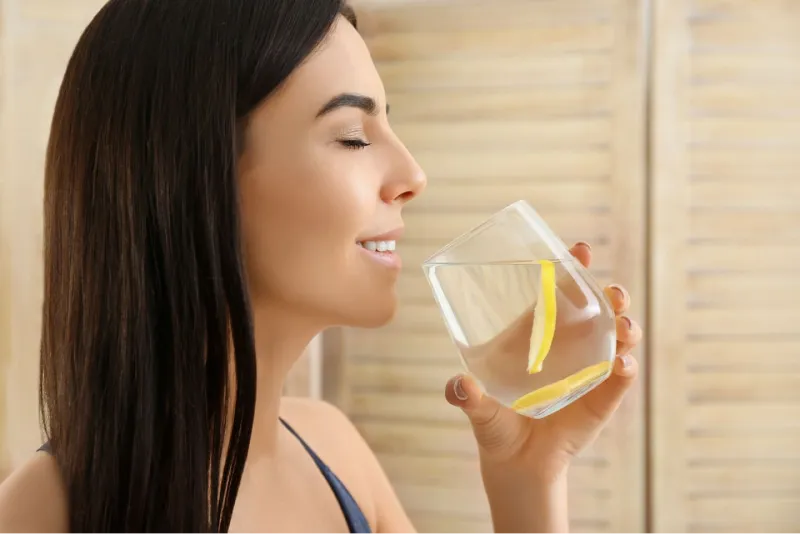 Giovane ragazze che beve acqua e limone