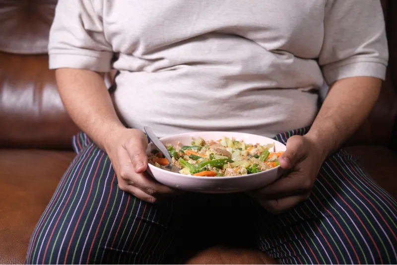Uomo in sovrappeso che si prepara a mangiare un insalata