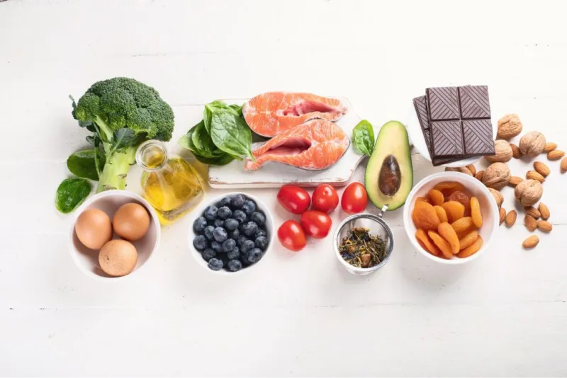 Varietà di cibi: verdure, pesce, cioccolato, uova, frutta secca