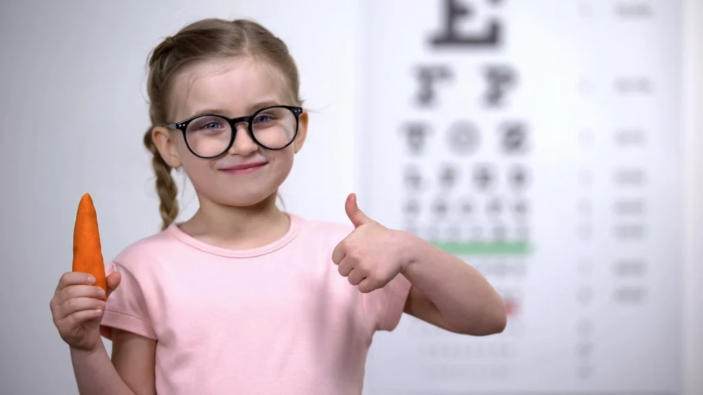 Bambina che mangia carote per preservare una buona vista