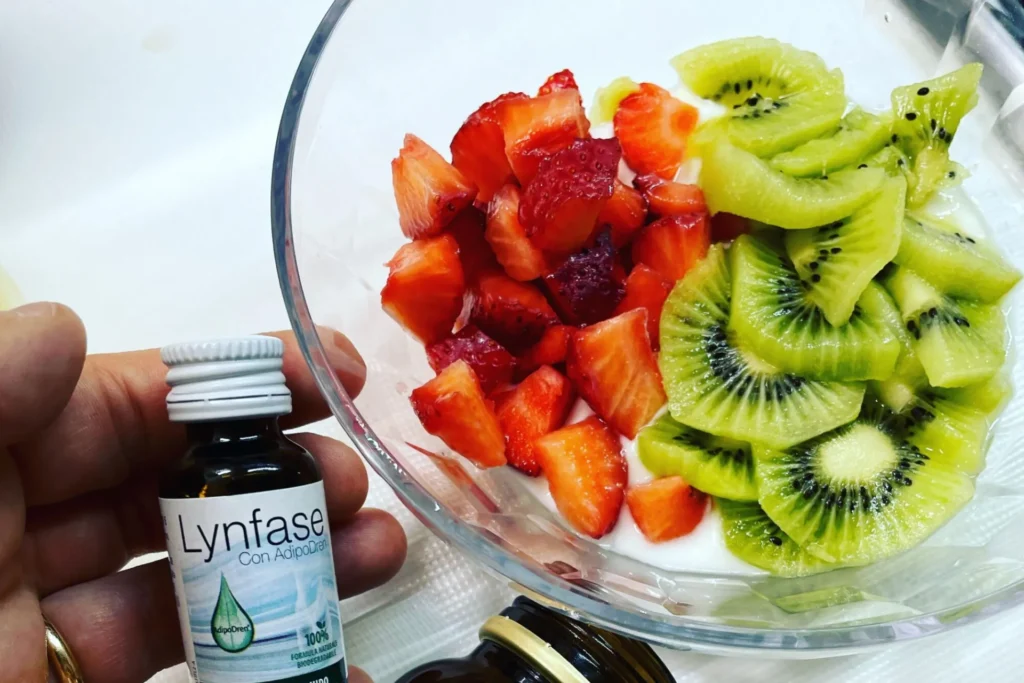 scodella con kiwi, fragole e yogurt, vicino una mano con prodotto lynfase