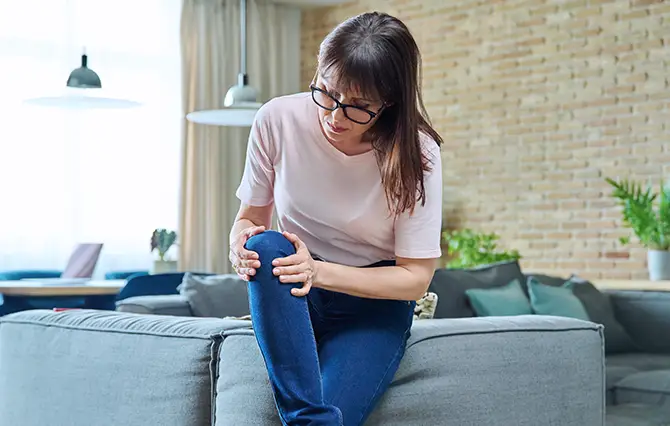 donna che sente dolori causati dall'osteoporosi in menopausa