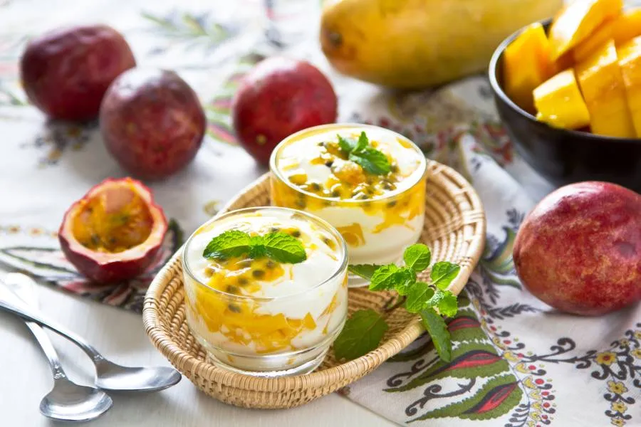 Tavolo imbandito con frutto della passione e bicchierini con yogurt alla maracuja e menta