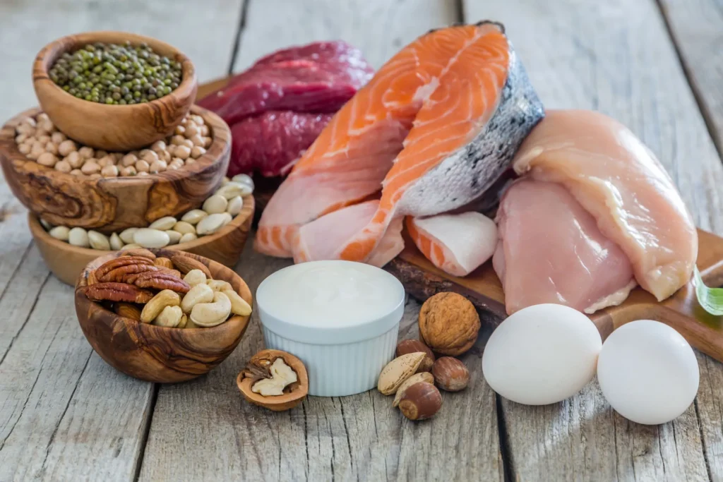 Tavolo ricco di proteine alimentari come carne, pesce uova e legumi