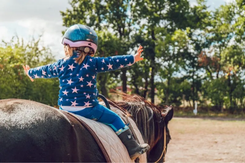 Foto di bambina che fa equitazione per mantenersi in forma