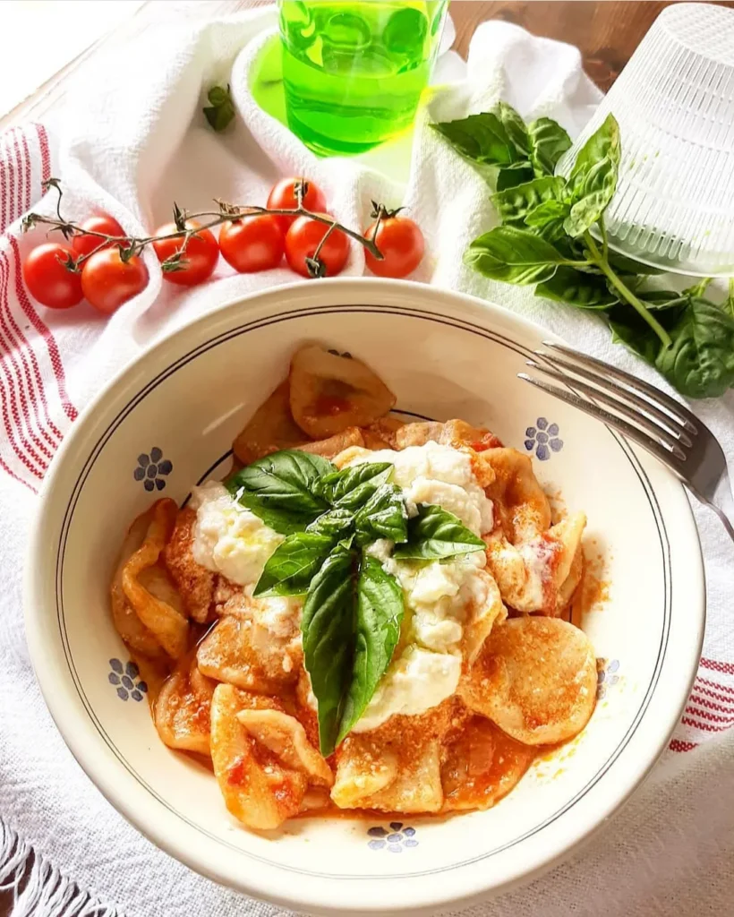 piatto di orecchiette al sugo con ricotta e basilico