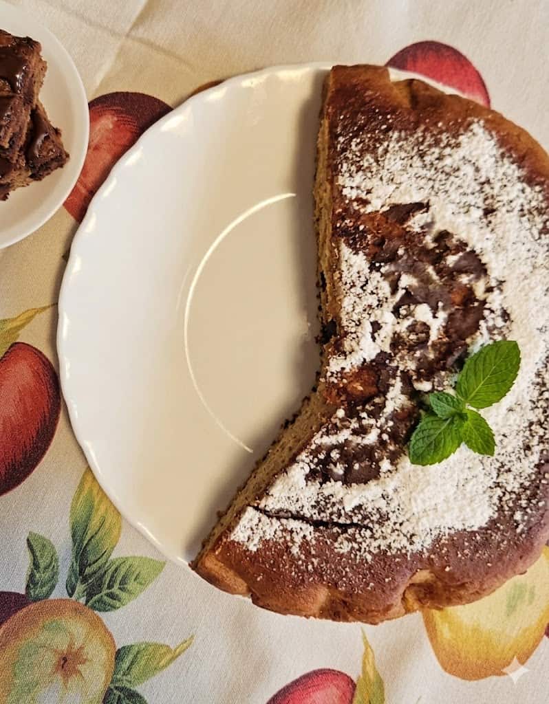 Torta al cioccolato e vaniglia con zucchero a velo, decorata con foglia di menta fresca.