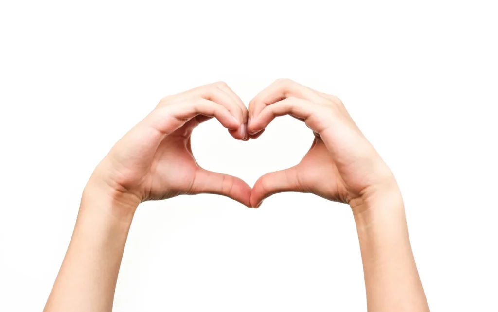 Mani che formano un cuore su sfondo bianco, simbolo di cura e prevenzione della salute cardiovascolare.