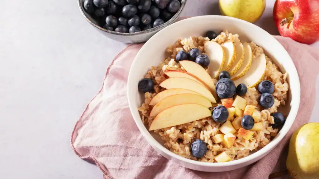 Piatto di cereali con mele, pesche e mirtilli freschi.
