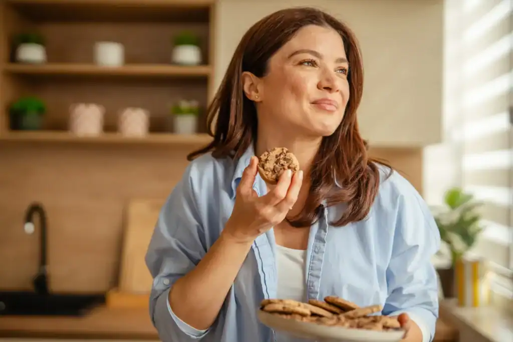 Donna felice con biscotti, promuovendo uno stile di vita sano.