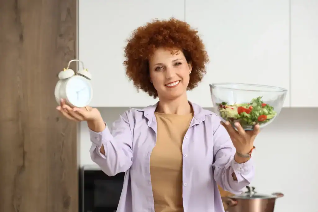Donna con orologio e insalata, salute metabolica.